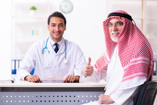 Old male arab visiting young male doctor - Zdjęcie, obraz