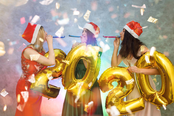 Three beautiful women with golden air balloons posing on new year party - Photo, Image