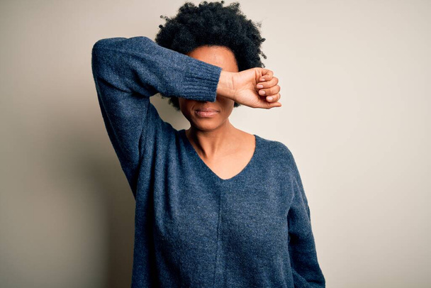 Молода афро-американська африканка з кучерявим волоссям, одягнена у звичайний светр, закриваючи очі руками, виглядає серйозною і сумною. Поняття безсилля, переховування та відмови - Фото, зображення
