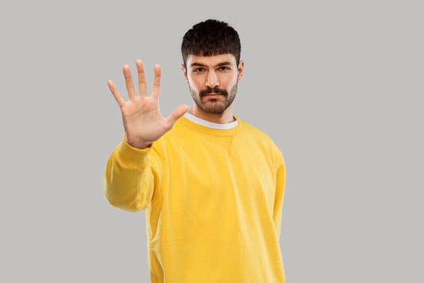 serious young man showing stop gesture - Fotó, kép