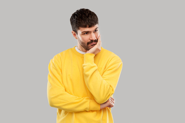 sad young man in yellow sweatshirt thinking - Φωτογραφία, εικόνα