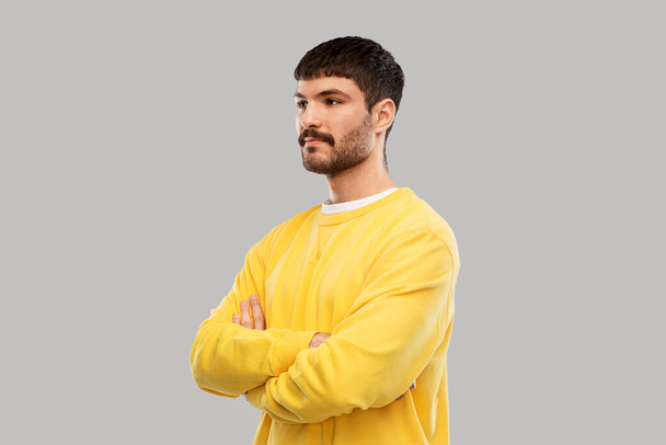 young man in yellow sweatshirt with crossed arms - Φωτογραφία, εικόνα