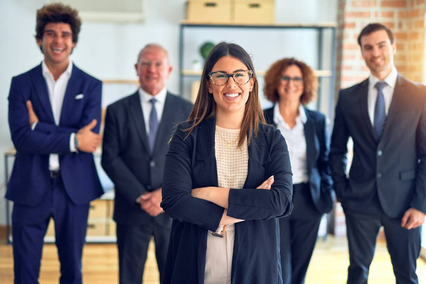 Grupo de empresários sorrindo feliz e confiante em uma reunião. De pé com sorriso no rosto olhando para a câmera no escritório
. - Foto, Imagem