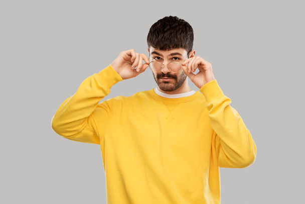 young man in glasses and yellow sweatshirt - Fotó, kép