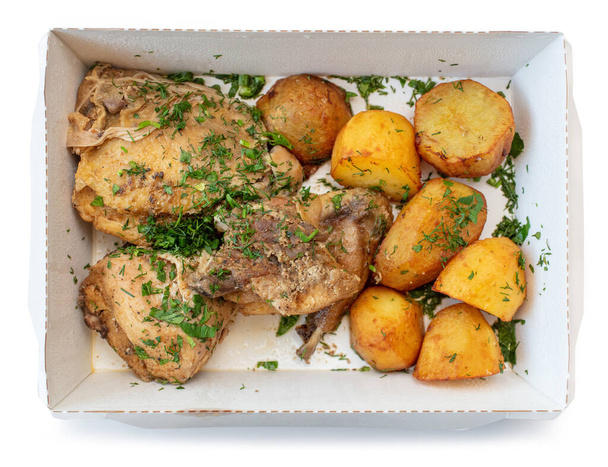 Papierschachtel zum Mitnehmen, isoliert auf weißem Hintergrund, Ansicht von oben. Hühnerfleisch und Kartoffeln - Foto, Bild