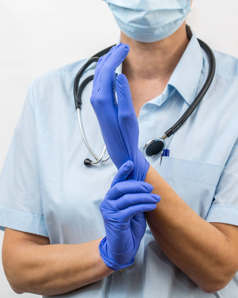 Koronavirová prevence. Lékař si nasadí rukavice na ochranu proti koronaviru a bakteriím. - Fotografie, Obrázek