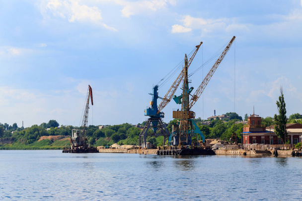 Grúas pesadas en puerto de carga en la orilla del río
 - Foto, Imagen