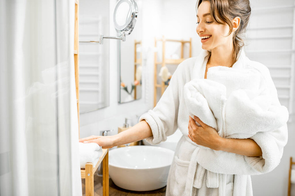 Женщина с полотенцами в ванной комнате
 - Фото, изображение