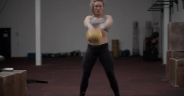 Γυναίκα αθλήτρια στο αθλητικό ντύσιμο Εκτέλεση Kettlebell Swing - Πλάνα, βίντεο