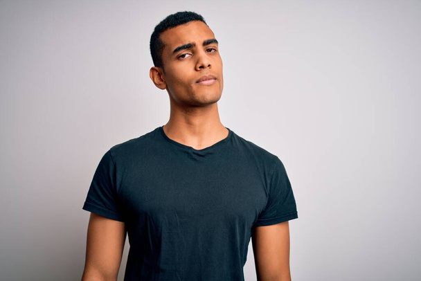 Young handsome african american man wearing casual t-shirt standing over white background looking sleepy and tired, exhausted for fatigue and hangover, lazy eyes in the morning. - Foto, imagen