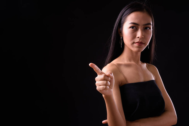 Portré fiatal gyönyörű ázsiai nő mutogató ujját - Fotó, kép