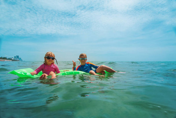 счастливые дети купаются в море, мальчик и девочка наслаждаются отдыхом
 - Фото, изображение