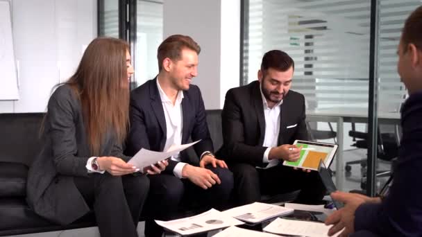 ryhmä neuvottelupöydän ääressä istuvia työntekijöitä nauraa ja jakaa ajatuksia uudesta hankkeesta kollegoidensa kanssa
 - Materiaali, video
