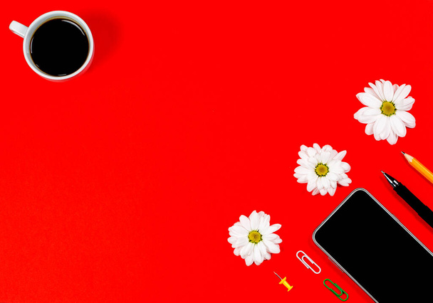 Vari articoli di cancelleria e tablet con un telefono per lavoro e studio e una tazza di caffè su sfondo rosso
 - Foto, immagini