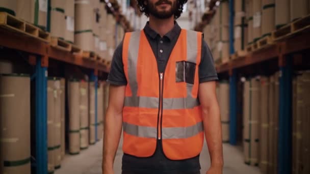 Inclinez-vous devant un jeune ouvrier d'entrepôt ou un superviseur dans un entrepôt souriant et regardant la caméra
 - Séquence, vidéo