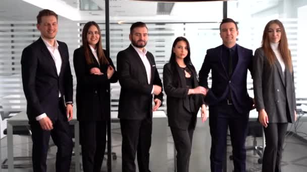 Ryhmä menestyneitä liikemiehiä seisomassa yhdessä toimistossa.
 - Materiaali, video