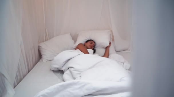 Calm young woman sleeping well in comfortable cozy fresh bed with canopy on soft pillow white linen orthopedic mattress, peaceful serene girl resting lying asleep enjoying healthy good sleep nap in - Metraje, vídeo