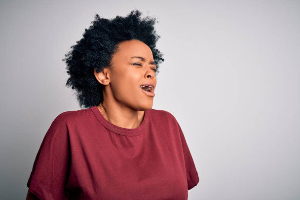 Nuori kaunis afroamerikkalainen nainen, jolla on kiharat hiukset päällään rento t-paita, joka seisoo käsi vatsassa, koska pahoinvointi, kivulias sairaus tunne huonovointisuus. Ache-käsite
. - Valokuva, kuva