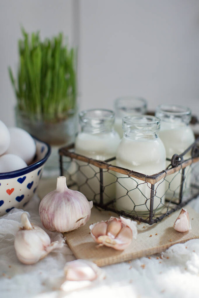 Productos agrícolas ecológicos. Huevos frescos, leche y ajo sobre un fondo blanco
 - Foto, imagen