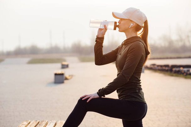 красива дівчина вранці тренування п'є воду з пляшки
 - Фото, зображення