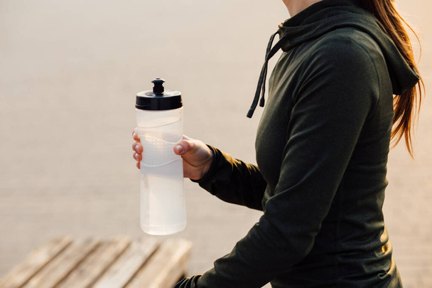 красивая девушка на утренней тренировке пьет воду из бутылки
 - Фото, изображение
