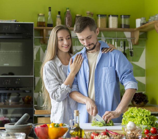 Jeune couple heureux de cuisiner un repas végétarien sain
 - Photo, image