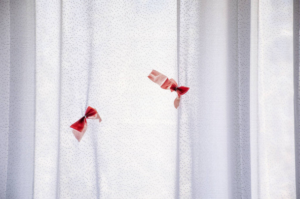 Window curtain with elements of red bows, curtain background. - Photo, Image
