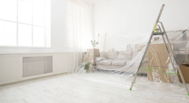 Canapé et boîtes recouverts de feuilles de poussière transparentes
 - Photo, image