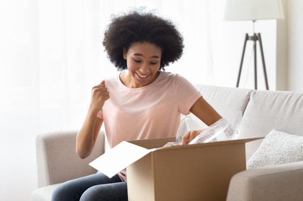 African american woman opens a box and rejoices - Foto, immagini