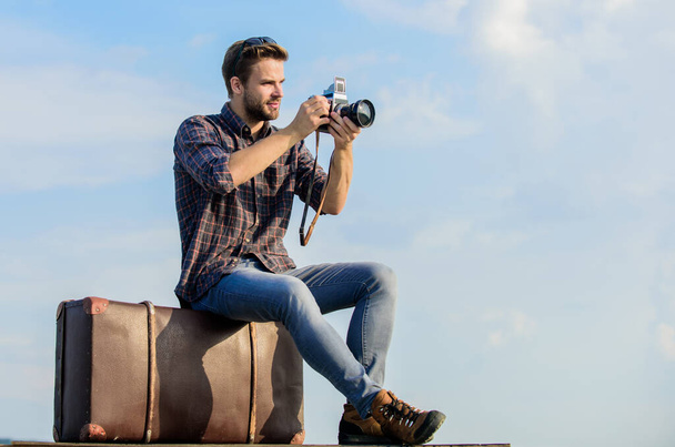 Travel blog. Man sit on suitcase. Handsome guy traveler retro camera. Guy outdoors with vintage suitcase. Photojournalist concept. Travel with luggage. Travel blogger. Shooting vlog. Vacation time - 写真・画像