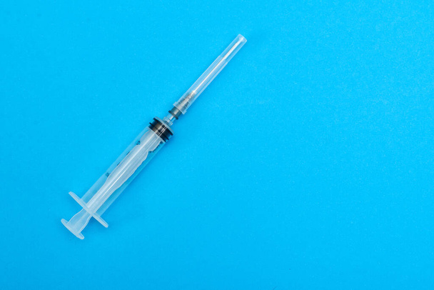 medical syringe on a blue background. - Φωτογραφία, εικόνα