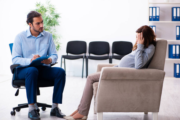 Mujer embarazada visitando joven psicólogo masculino - Foto, Imagen