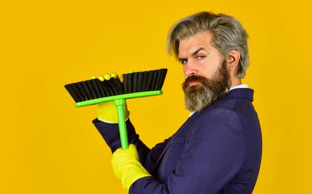 On guard of order. Cleaning day. Sweep in office. Hipster enjoy cleanliness. Cleaning business. Household duties. Cleaning service concept. Clear reputation. Bearded man formal suit hold broom brush - 写真・画像