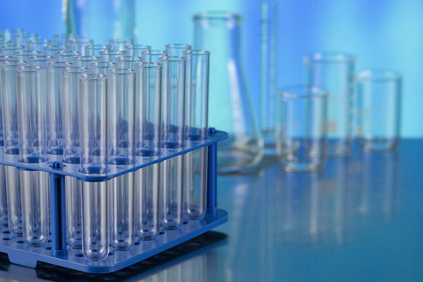 Laboratoriumreageerbuizen als symbool voor medische tests op de metalen tafel en blauwe achtergrond - Foto, afbeelding
