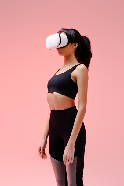 young african american woman in in sportswear and virtual reality headset on pink  - Fotografie, Obrázek