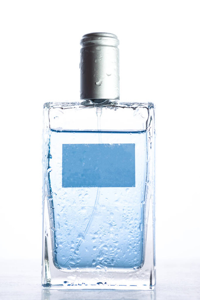 Blue men's perfume on a white background with drops - Foto, imagen