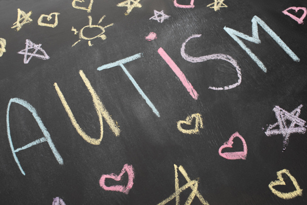 high angle view of chalkboard with autism inscription, hearts, stars and suns - 写真・画像