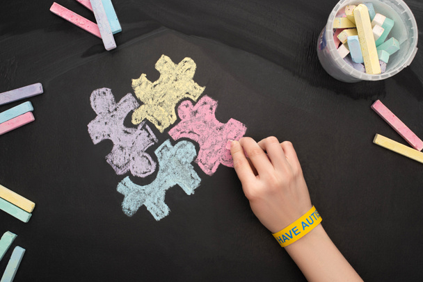 widok z góry kobieta w bransoletka rysunek puzzle z kredą rof World Autism Awareness Day - Zdjęcie, obraz