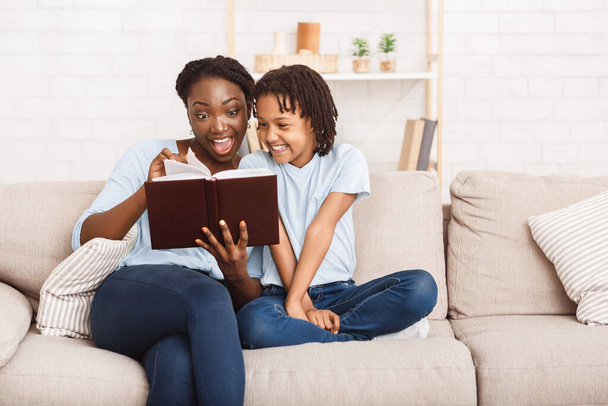 Libro de lectura familiar afro feliz en sala de estar
 - Foto, Imagen