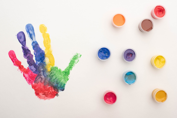 vista superior de la huella de mano de colores y pinturas en blanco para el Día Mundial de la Concientización sobre el Autismo
 - Foto, Imagen