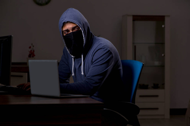 Άντρας χάκερ hacking τείχος προστασίας ασφαλείας αργά στο γραφείο - Φωτογραφία, εικόνα
