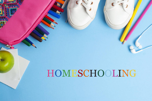 Magántanuló szöveg kék háttérrel színes ceruzákkal és sportcipőkkel. Tanulj otthonról. - Fotó, kép