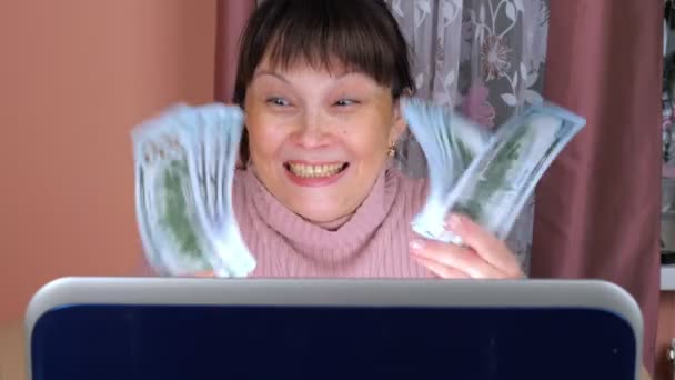 Woman uses a laptop to make money on the Internet - Filmati, video