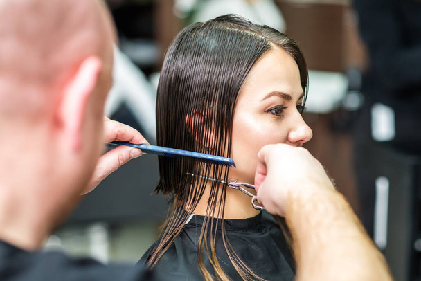 Boční pohled na kadeřníka stříhání vlasů ženy. - Fotografie, Obrázek