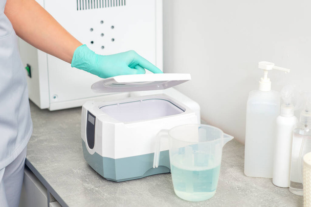 Doctor disinfects the tool. Cleaning systems for medical instruments. Ultrasonic cleaner. - Valokuva, kuva