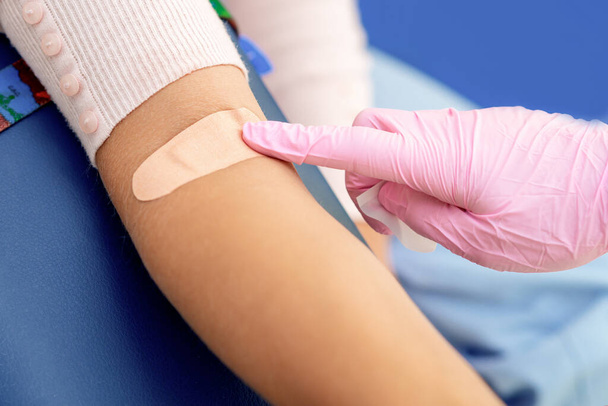 医療センターで注射ワクチンを与える前に綿で腕の皮膚を消毒看護師. - 写真・画像