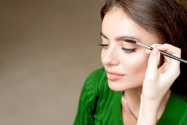 Maquillaje artista peina las cejas con la herramienta de cepillo de cejas copia espacio
. - Foto, imagen