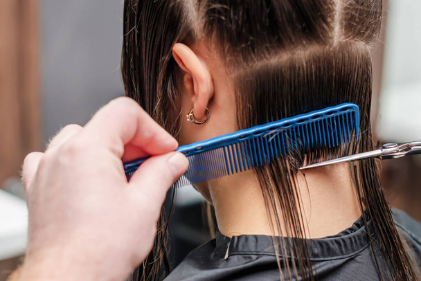 Friseur schneidet Frau im Friseursalon die Haare aus nächster Nähe. - Foto, Bild