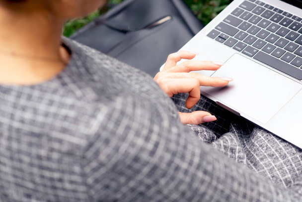 Close-up van de vrouw vinger en hand is met behulp van touchpad van laptop computer. Vrouwelijke hand maakt gebruik van een touchpad op een laptop voor surfen op internet. - Foto, afbeelding