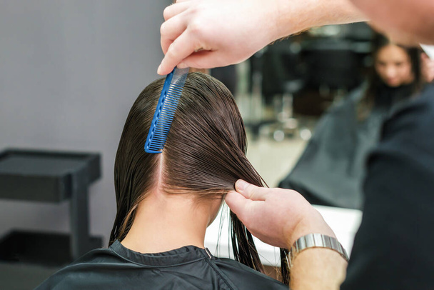 Friseur kämmt nasse Frauenhaare während der Frisur, Nahaufnahme. - Foto, Bild
